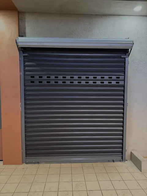 Cortina de acero oscura con ranuras de ventilación